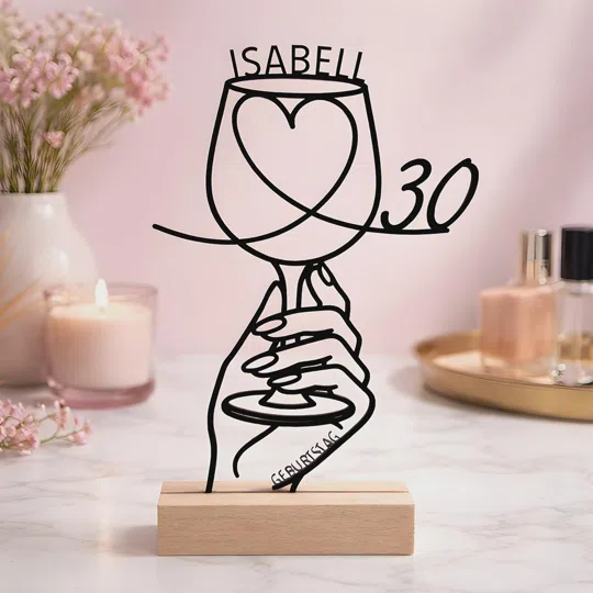 Personalisierten Aufsteller zum 30. Geburtstag bestellen: schwarze Linienfigur aus Händen mit Pokalglas und Herz, darüber ein Name und seitlich die 30, auf einem hellen Sockel.