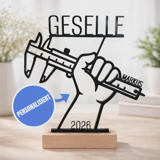 Gesellen-Aufsteller personalisiert kaufen: schwarze Silhouette einer Hand mit Messschieber, Schriftzug „Geselle“, Name und Jahreszahl 2026 auf einem hellen Sockel.