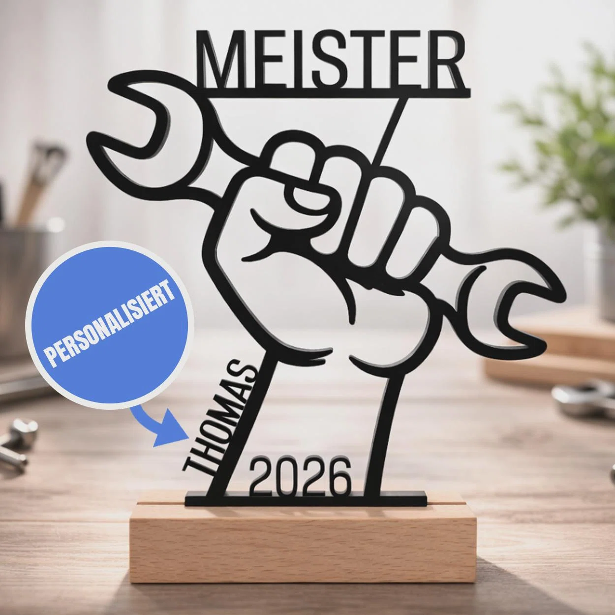 Meister-Aufsteller personalisiert kaufen: Schwarze Konturen zeigen eine Faust mit Schraubenschlüssel, darüber „Meister“, dazu Name und Jahreszahl auf einem hellen Sockel.