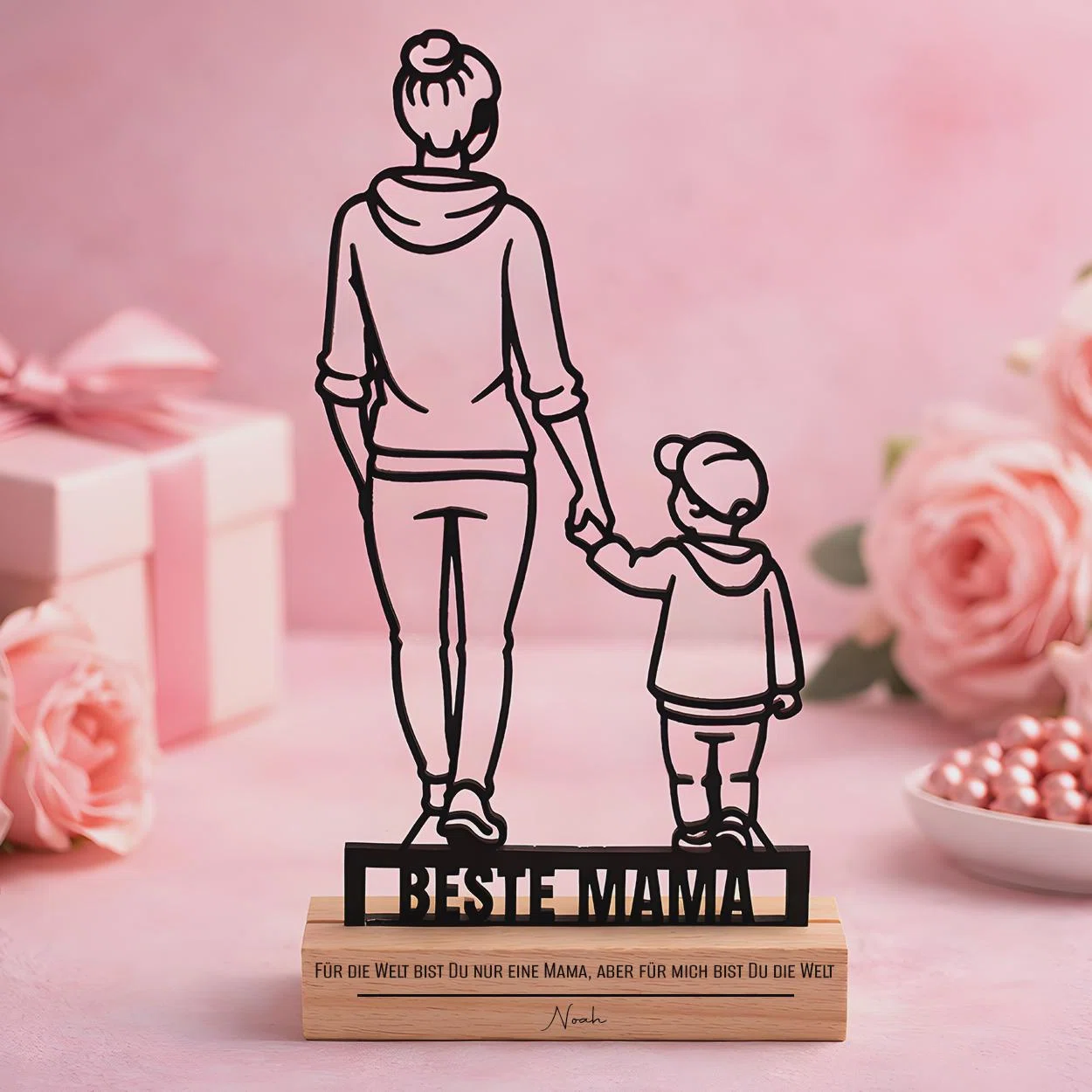 Schwarze Silhouetten-Dekoration mit einer erwachsenen Person und einem Kind, von hinten Hand in Hand dargestellt. Auf dem rechteckigen Sockel stehen „Beste Mama“ und ein liebevoller Spruch.