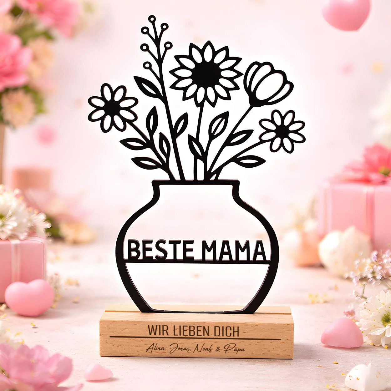 Blumenaufsteller für Mama bestellen: schwarze Vasen-Silhouette mit fünf Blüten und „Beste Mama“, auf einem hellen Sockel mit „Wir lieben dich“ und Namen.