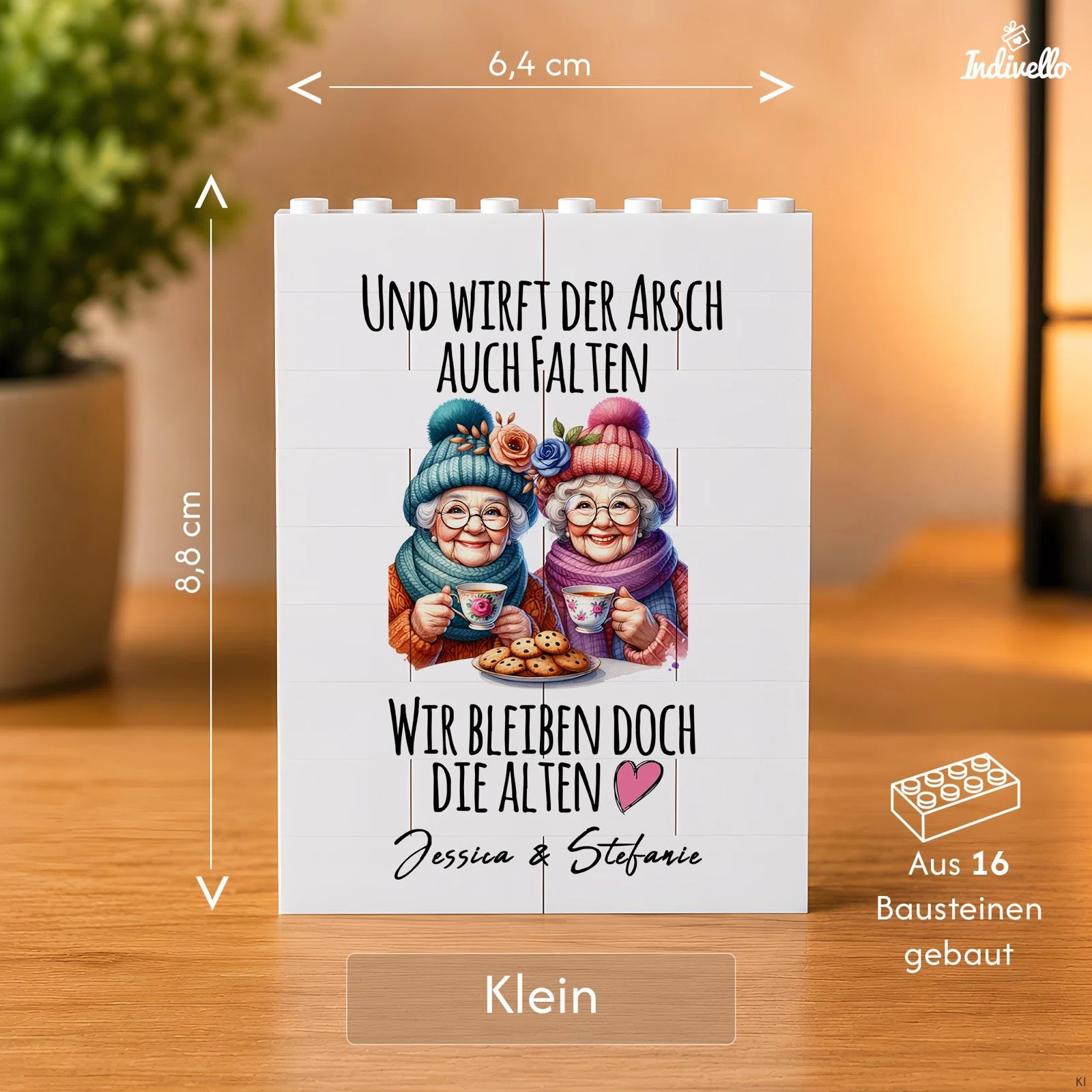 Größenansicht der kleinen Baustein-Tafel: 6,4 cm breit und 8,8 cm hoch, aus 16 Steinen gebaut. Das Motiv zeigt zwei Frauen mit Mützen, Tassen und Keksen sowie einen humorvollen Freundschaftsspruch.