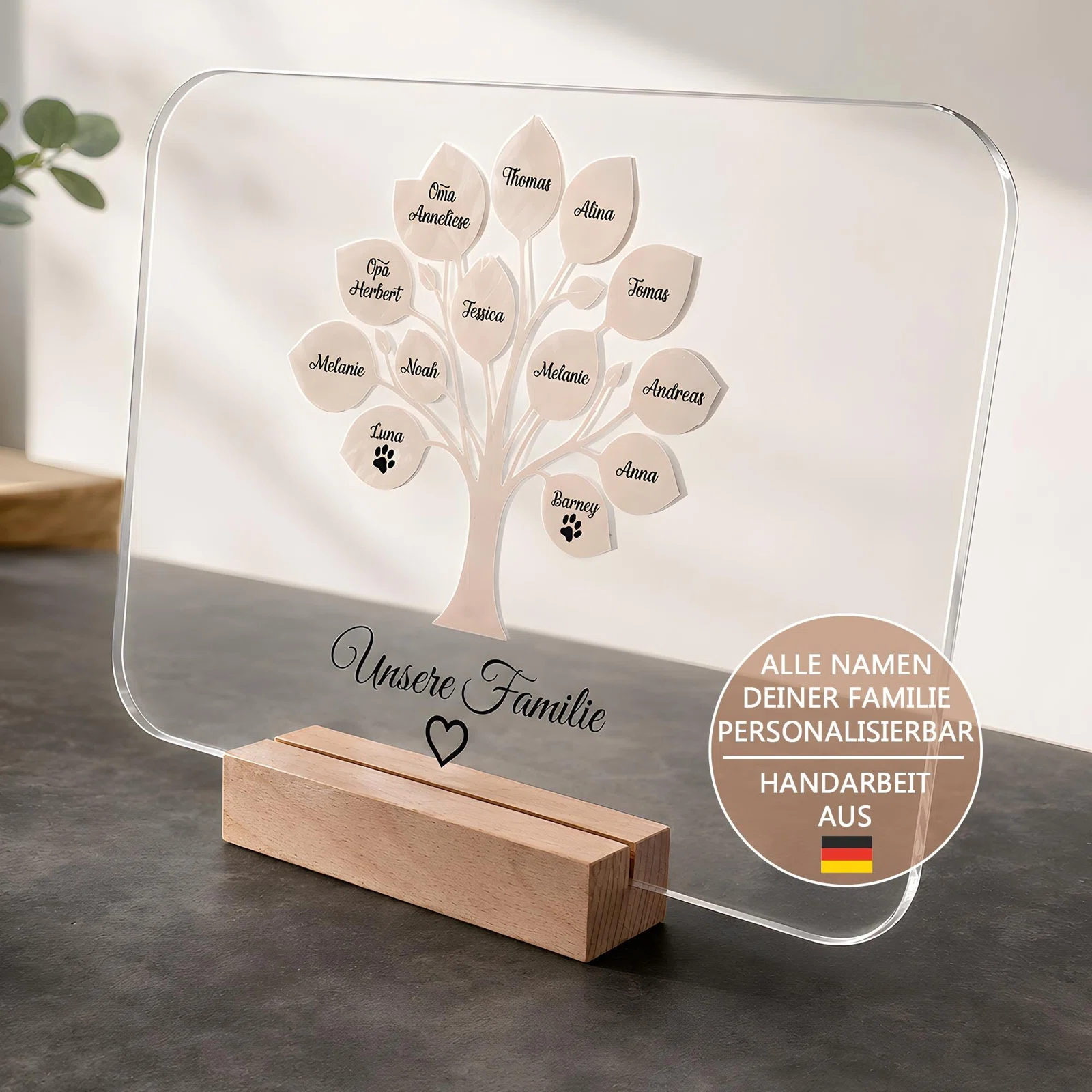 Personalisierten Stammbaum-Aufsteller kaufen: transparente, abgerundete Familientafel in einem holzfarbenen Steckfuß, mit Namensblättern und zwei Blättern mit Pfotenmotiven.
