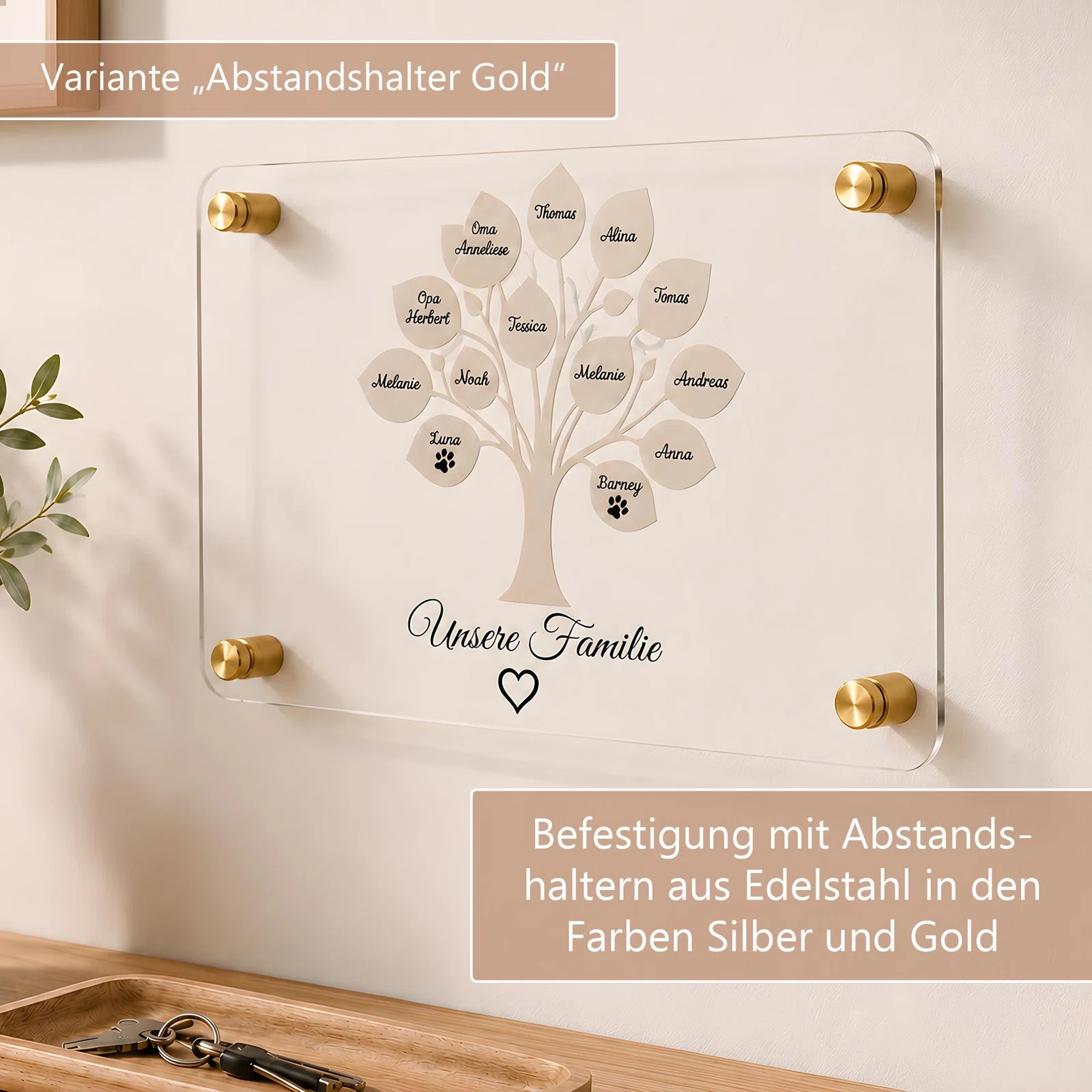 Infografik zur Wandbefestigung einer transparenten Familientafel mit vier Abstandshaltern aus Edelstahl. Gezeigt ist die goldfarbene Variante; alternativ ist Silber erhältlich.