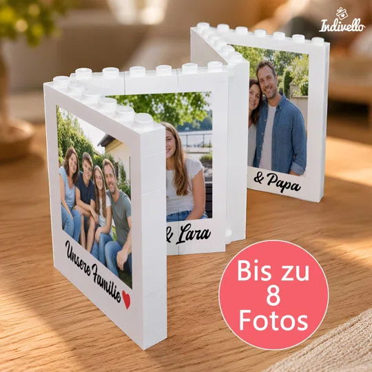 Personalisierten Fotorahmen aus Steckbausteinen bestellen: weißer, zickzackförmig aufgeklappter Rahmen mit mehreren Fotos und individuellen Beschriftungen auf einem Holztisch.