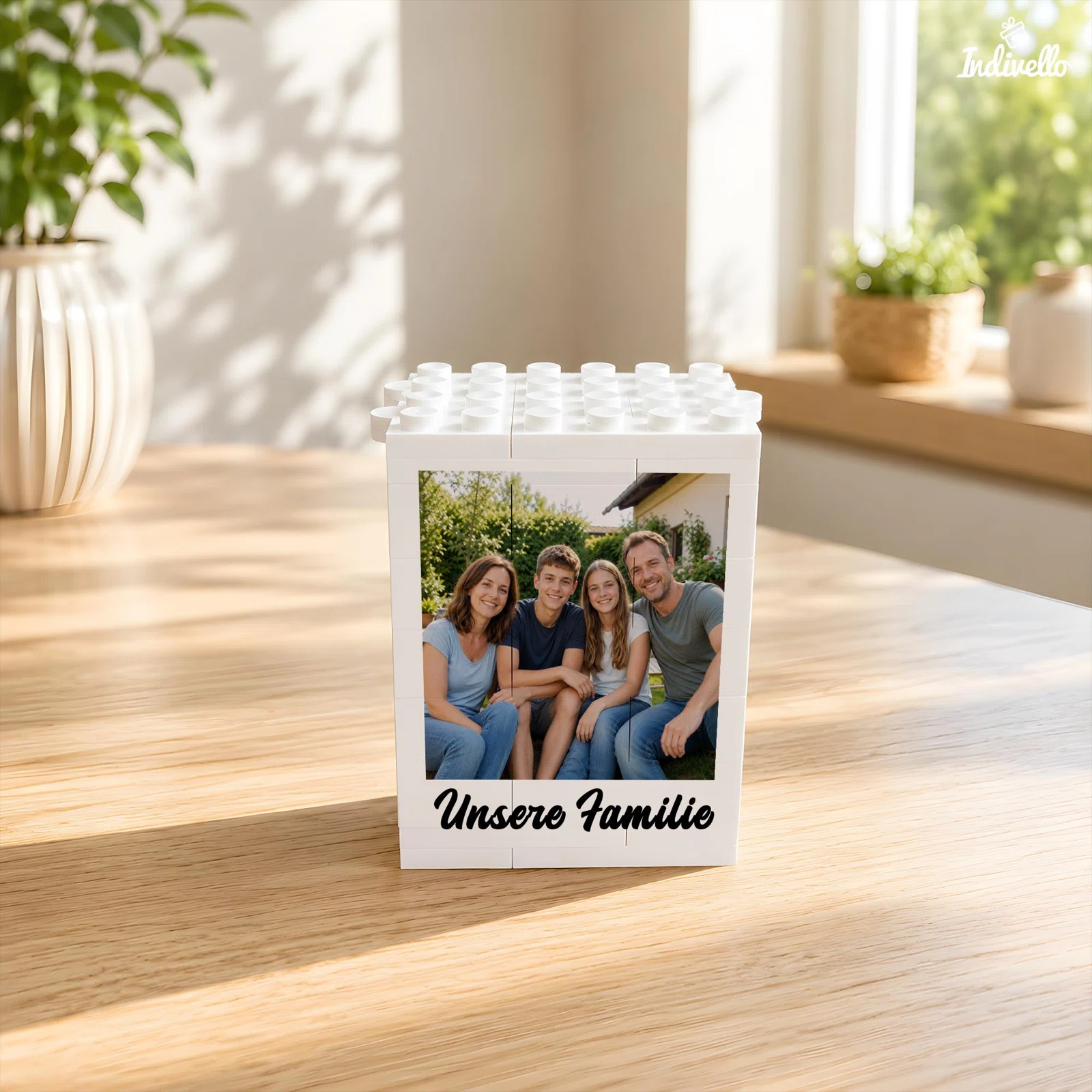 Weißer, rechteckiger Bilderrahmen in Bausteinoptik mit Noppen an der Oberseite. Frontal eingesetzt sind ein Gruppenfoto und der Schriftzug „Unsere Familie“.
