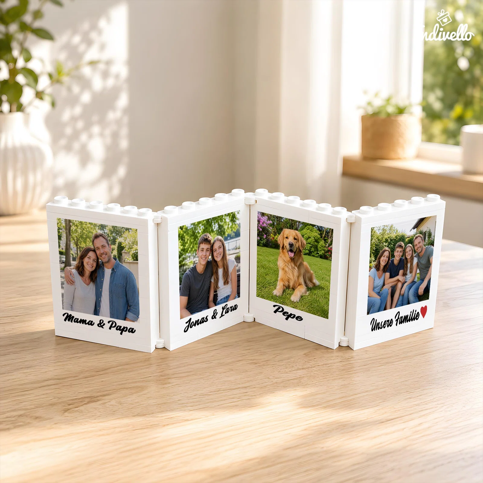 Weißer, vierteiliger Fotorahmen in Zickzack-Aufstellung mit noppenartigem Rand. Die vier Bilder von Personen und einem Hund sind jeweils mit schwarzer Schreibschrift beschriftet, eines mit rotem Herz.