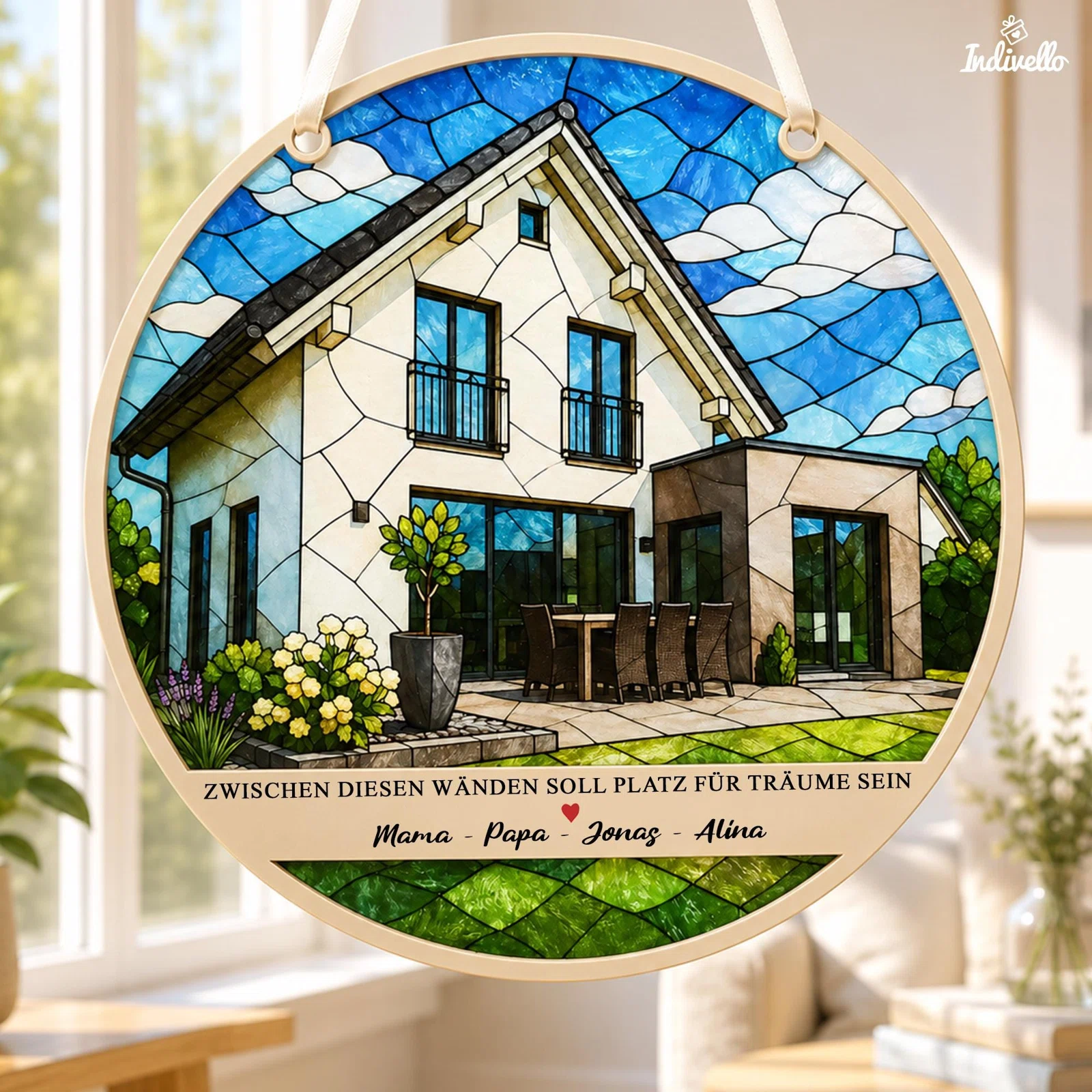 Ovale Fensterdekoration zum Aufhängen im Buntglasstil, frontal gezeigt: modernes Haus mit Terrasse und Garten unter blauem Himmel, darunter ein Familienspruch, rotes Herz und personalisierbare Namen.
