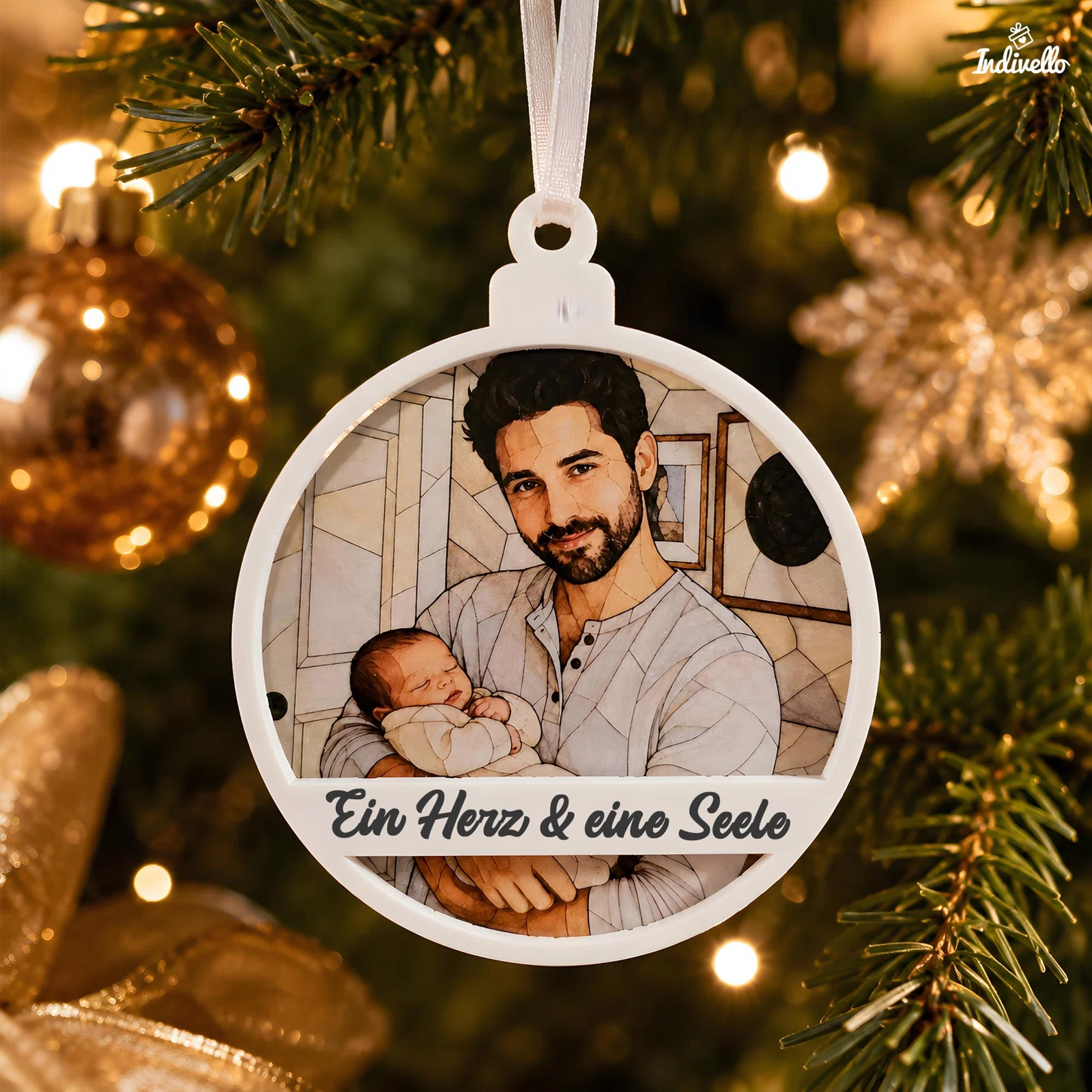 Runder weißer Weihnachtsanhänger mit stilisiertem Porträt eines bärtigen Erwachsenen, der ein Baby im Arm hält, und dem Schriftzug „Ein Herz & eine Seele“. Frontal am beleuchteten Tannenbaum fotografiert.