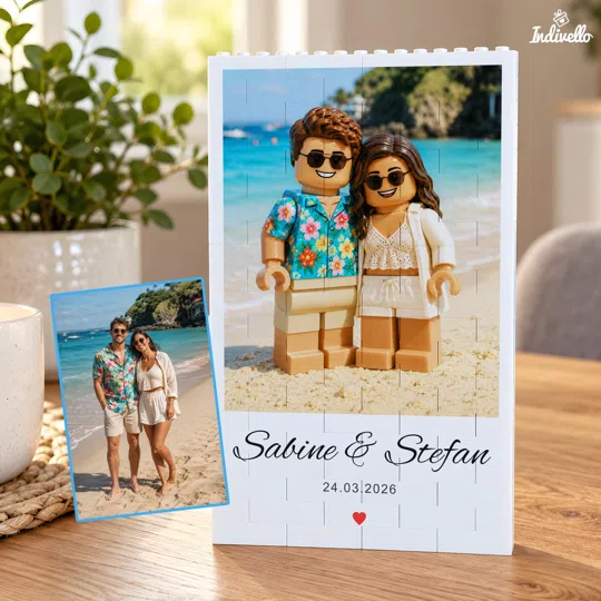 Personalisiertes Fotogeschenk im Baustein-Stil bestellen: hochformatiges Porträt zweier Figuren vor türkisblauem Strandmotiv, mit Namen, Datum und rotem Herz unter dem Bild.
