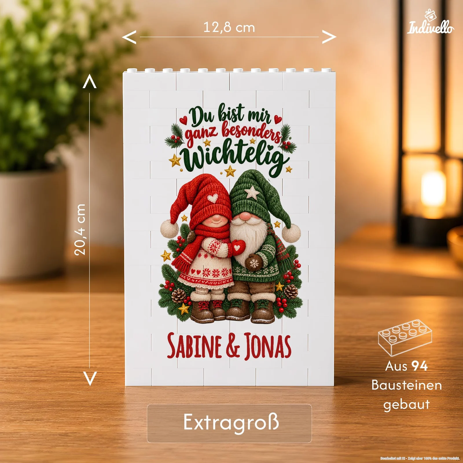 Frontalansicht einer weißen, rechteckigen Dekoplatte aus 94 Bausteinen auf einem Holztisch. Das Weihnachtsmotiv zeigt zwei Wichtel in Rot und Grün mit Tannenzweigen sowie den Aufschriften „Du bist mir ganz besonders wichtelig“ und „Sabine & Jonas“.