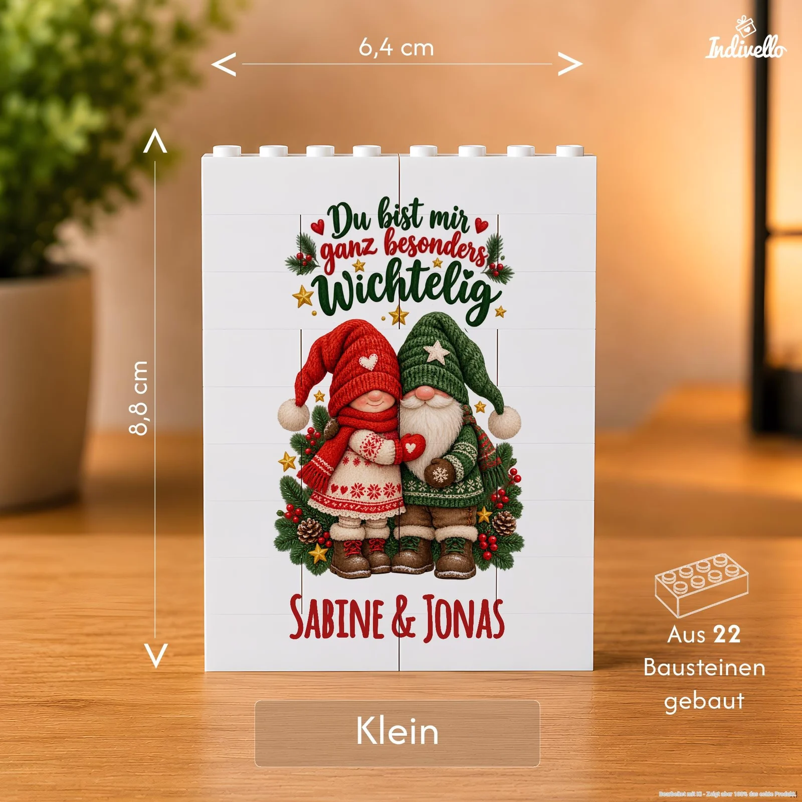 Frontansicht einer kleinen weißen Tafel aus 22 Bausteinen auf einem Holztisch. Das weihnachtliche Motiv zeigt zwei Wichtel in Rot und Grün mit Tannenzweigen, Sternen und dem Spruch „Du bist mir ganz besonders wichtelig“ sowie den Namen „Sabine & Jonas“.