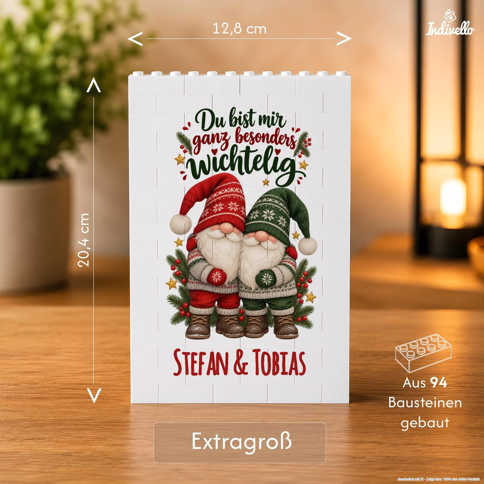 Frontansicht einer weißen Deko-Tafel aus Bausteinen auf einem Holztisch, bedruckt mit zwei Weihnachtswichteln in Rot und Grün, Tannenzweigen und Sternen. Darüber steht „Du bist mir ganz besonders wichtelig“, darunter „Stefan & Tobias“; die Infografik kennzeichnet die Variante als „Extragroß“ und aus 94 Bausteinen gebaut.