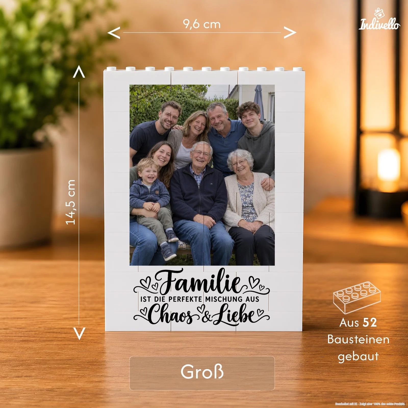Frontansicht eines weißen, aus Bausteinen zusammengesetzten Bilderrahmens mit einem Gruppenfoto und dem Aufdruck „Familie ist die perfekte Mischung aus Chaos & Liebe“. Der Rahmen steht auf einem Holztisch in einem warm beleuchteten Wohnraum; die Grafik weist auf 52 Bausteine hin.
