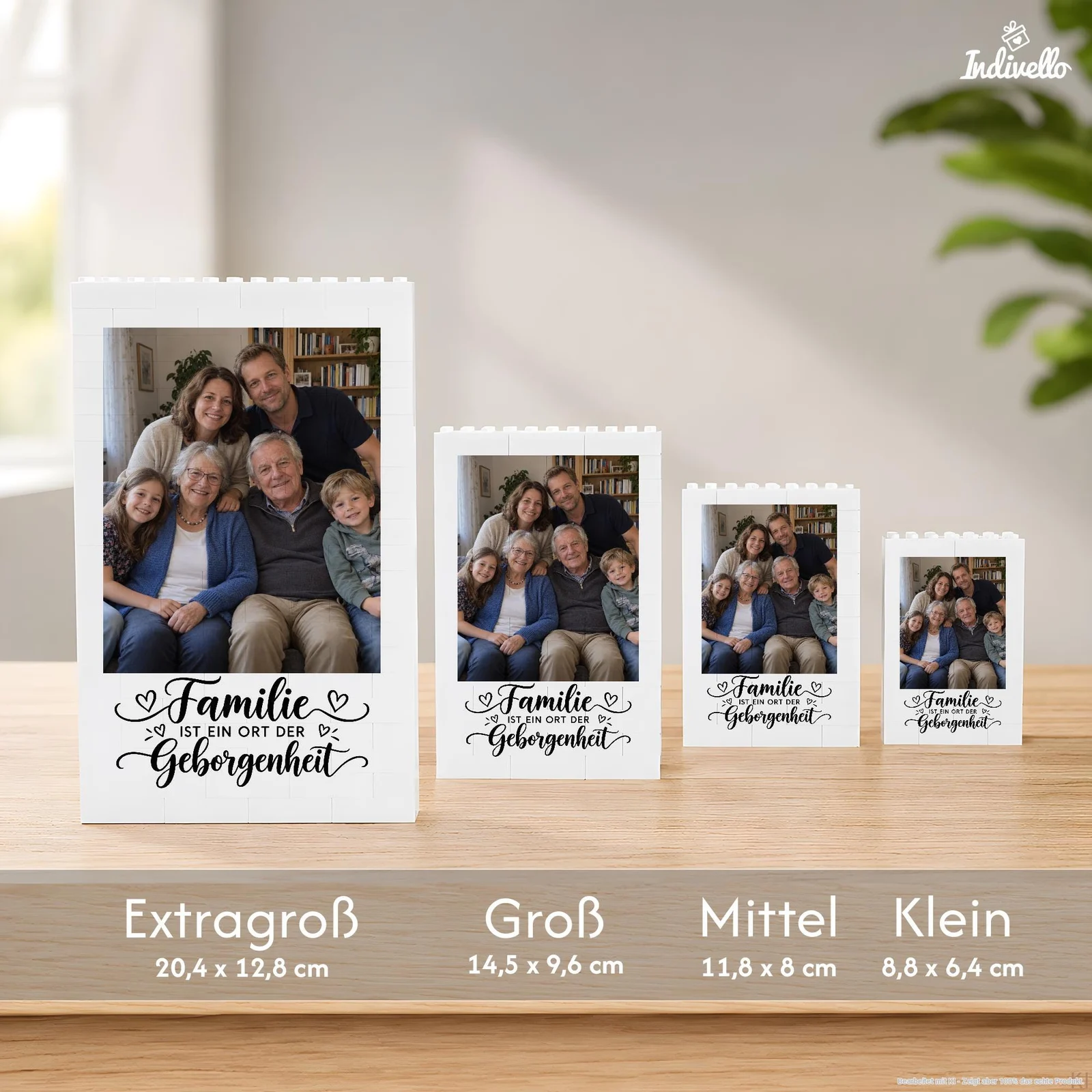 Vier weiße, bausteinartig gestaltete Fotorahmen in den Größen „Extragroß“, „Groß“, „Mittel“ und „Klein“ stehen frontal auf einem Holztisch. Jeder zeigt dasselbe Gruppenfoto sowie den schwarzen Schriftzug „Familie ist ein Ort der Geborgenheit“ mit kleinen Herzen.